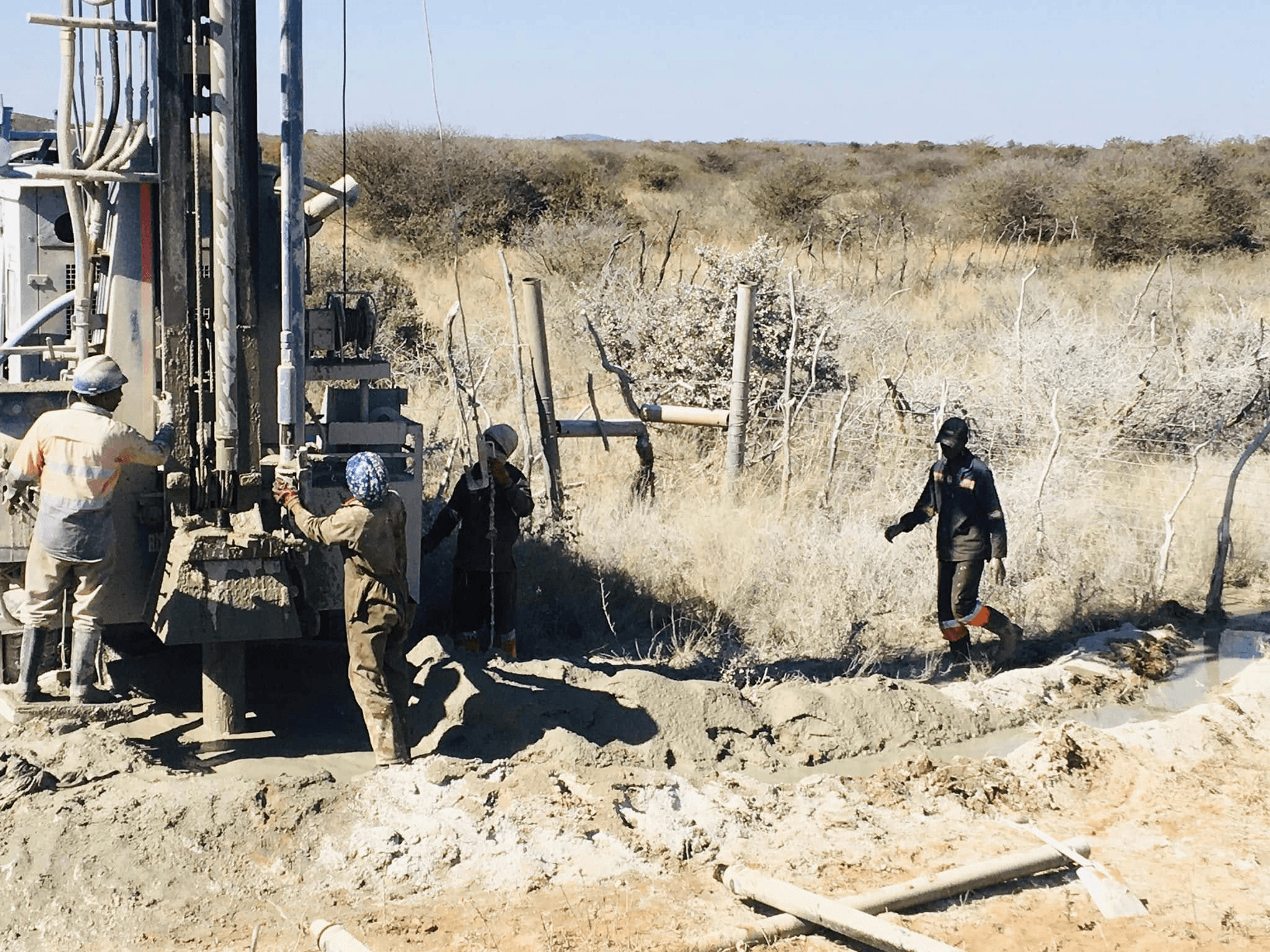 Crew operating a water well drilling rig