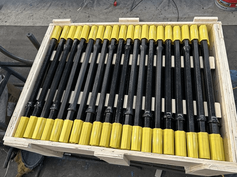 Drill rods packed with protective end caps in a wooden case
